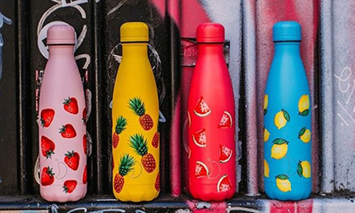 Four water bottles in a line each with a different fruit pattern.